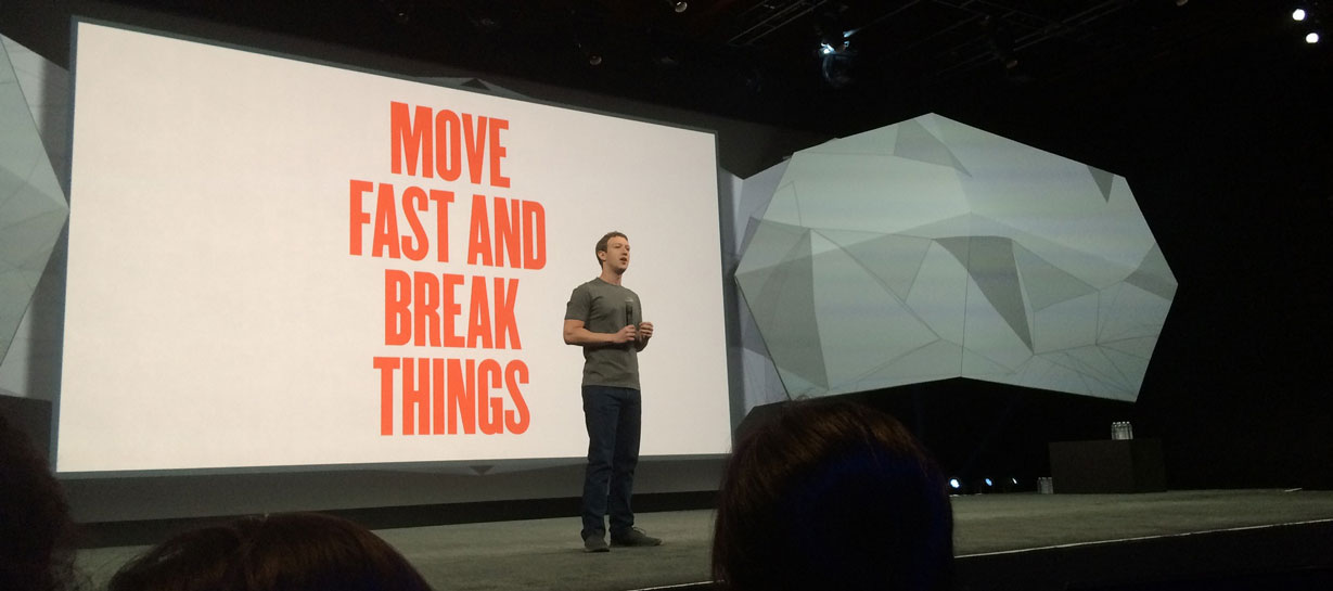 Mark Zuckerberg in front of a Move Fast poster